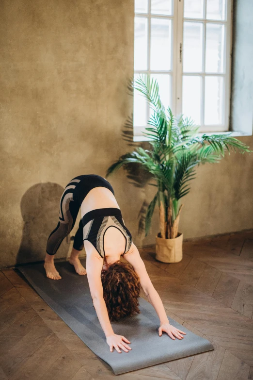 a woman is doing a yoga pose in the middle of the room