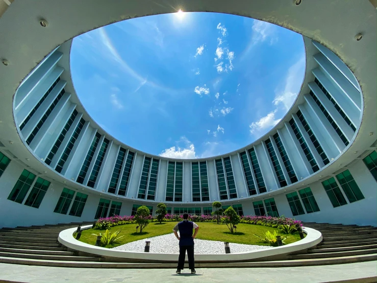 a man standing in a large building under a blue sky