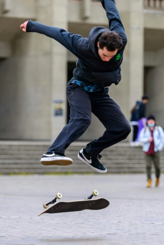 a young man doing a skateboard trick on concrete