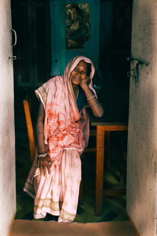 an older woman sitting on a chair smiling at the camera