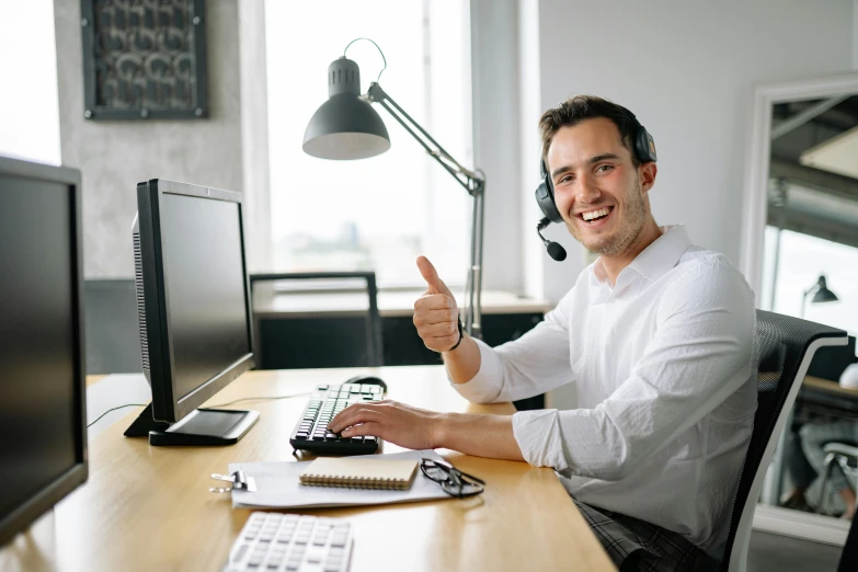 a man with a headset sitting at a computer