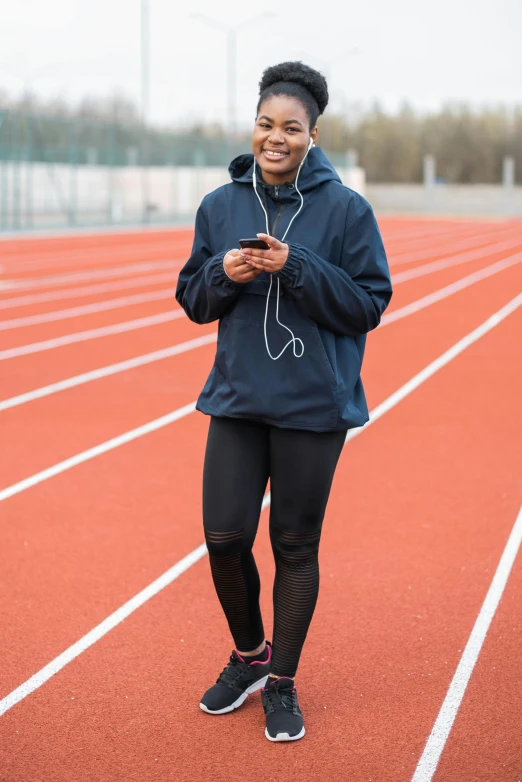 woman smiling at camera while walking on track