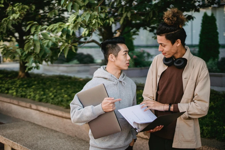 two young men are on the street talking and smiling