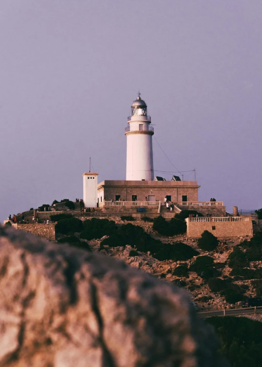 a large stone wall with a white lighthouse on top