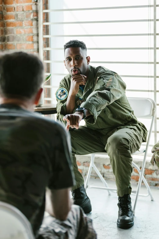 a man in military clothing is sitting down with another person