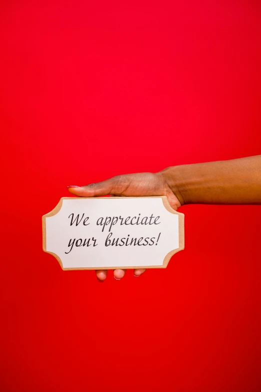a woman holding up a piece of paper with a sign saying we appreciate your business