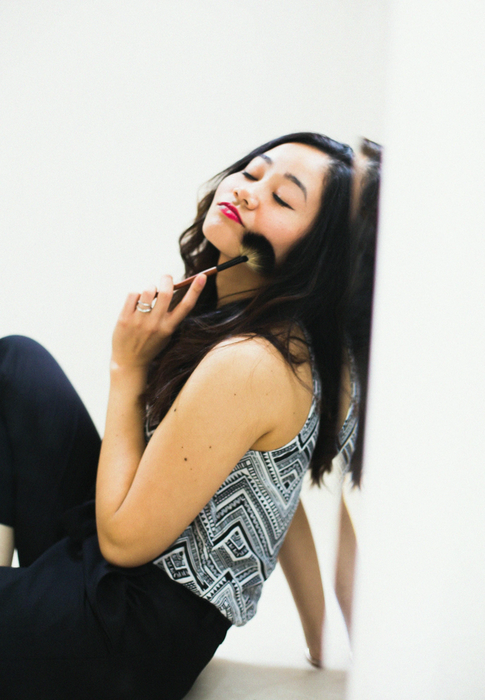 a pretty young lady laying down talking on a cell phone