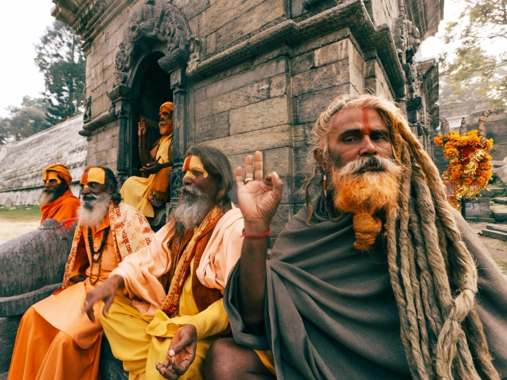 some men in their daily clothes sitting and standing