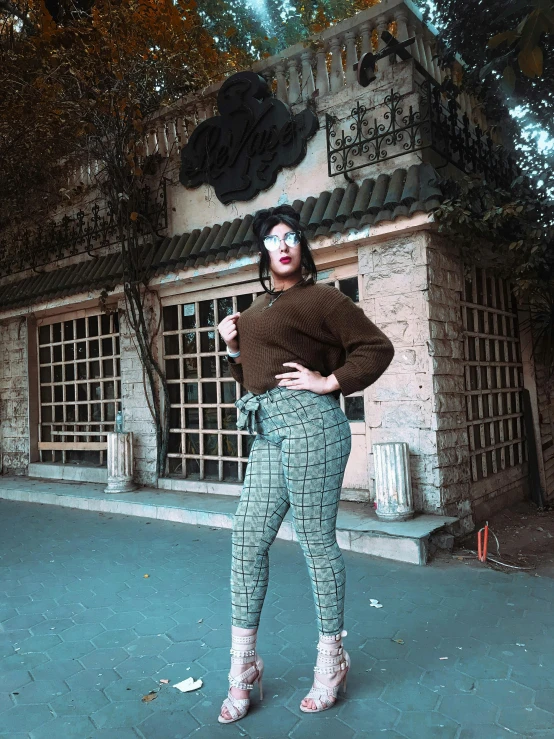 a beautiful woman standing next to a building wearing animal printed clothes