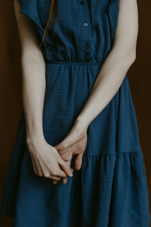 a woman standing with hands behind her back