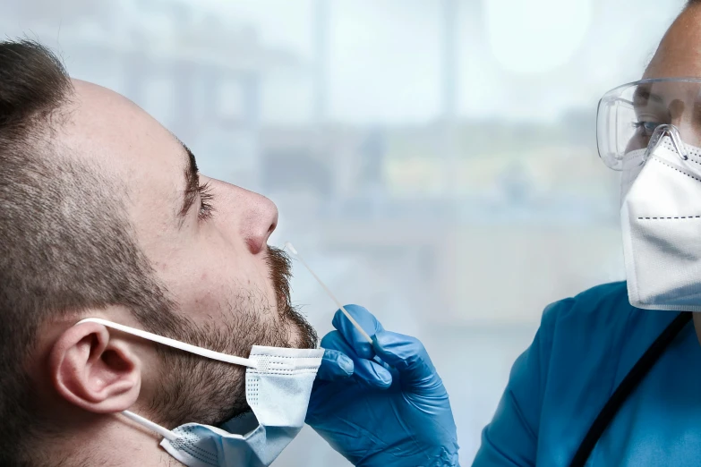 a person wearing safety glasses putting on a protective face mask