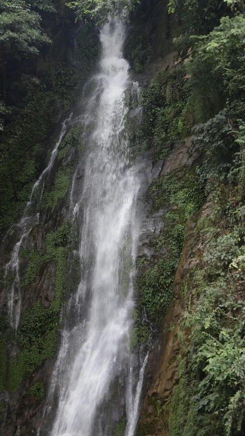 waterfall in the mountains with a boat in front