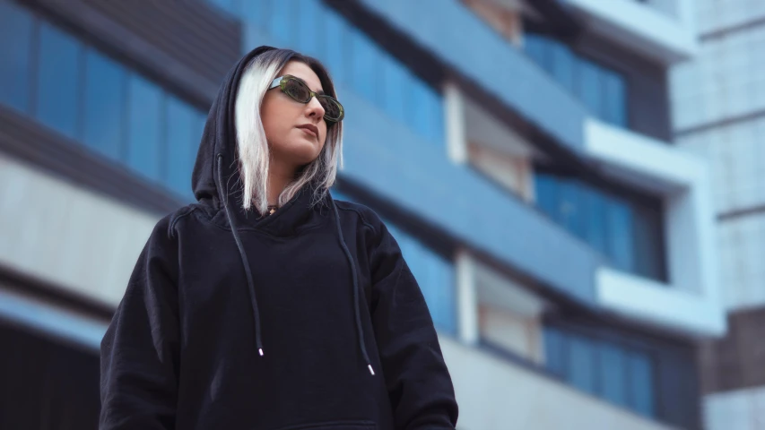 a person wearing a black hoodie with shades on
