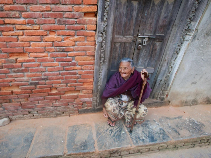 an older man is sitting down by the door