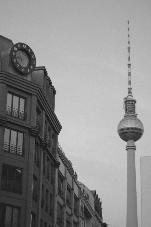 a black and white po shows a clock tower next to buildings