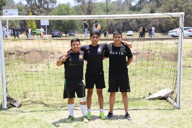 two soccer players and a ball player stand by the net