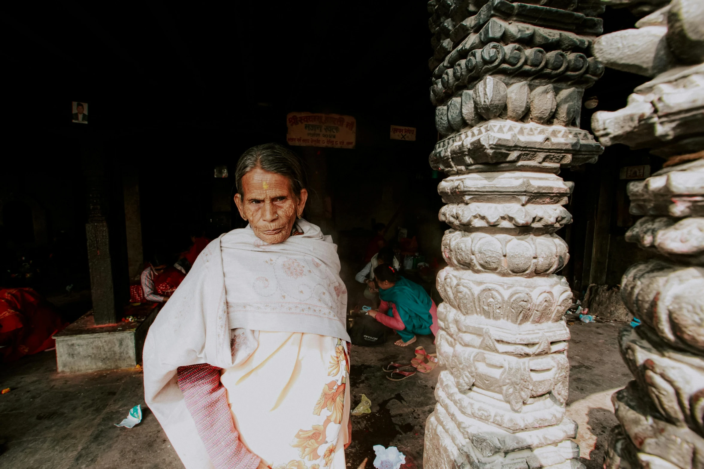 a woman standing in a doorway next to a pole