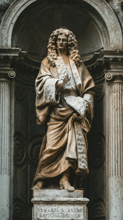 a statue in the middle of a pillar in front of a building