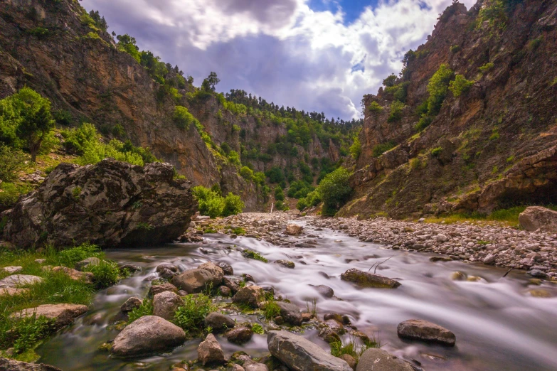 a stream running through a canyon in a mountainous area