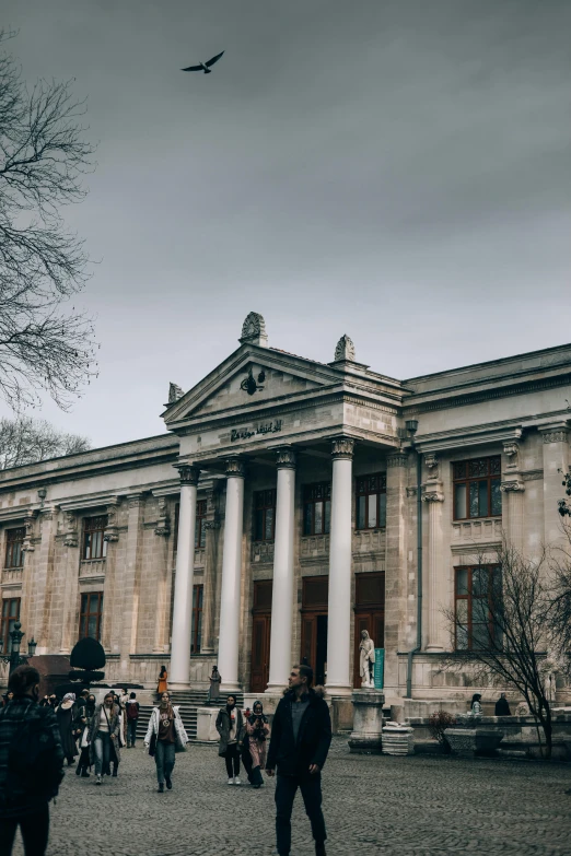 people walk through front of the old bank building