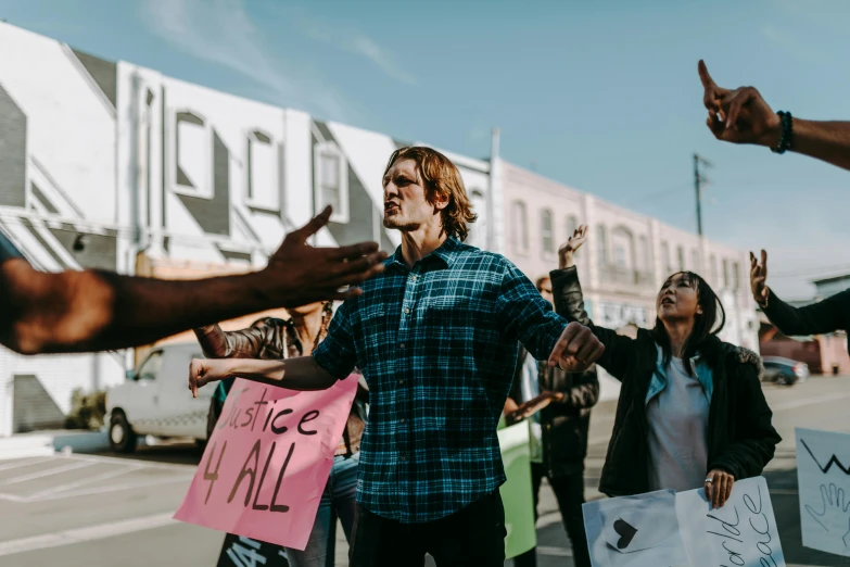 a group of people standing in the street with their hands raised