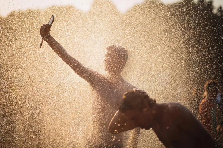 a man standing under water spraying up from his hands