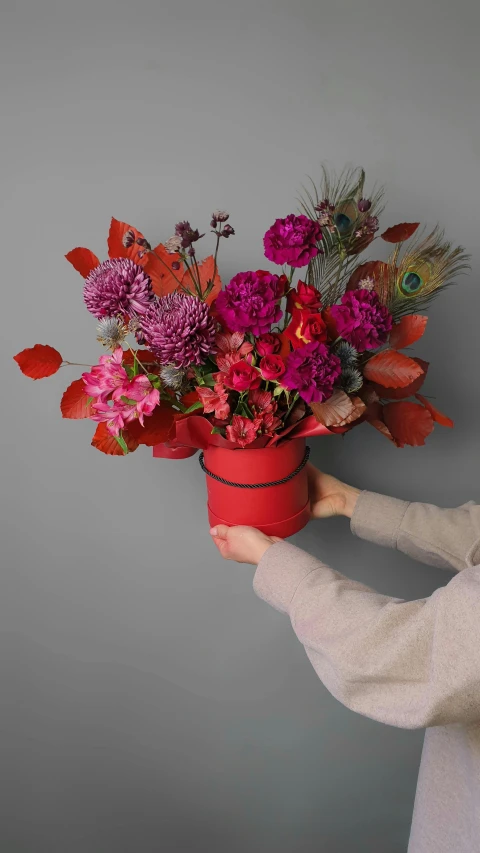 a woman with a flower pot holding some flowers