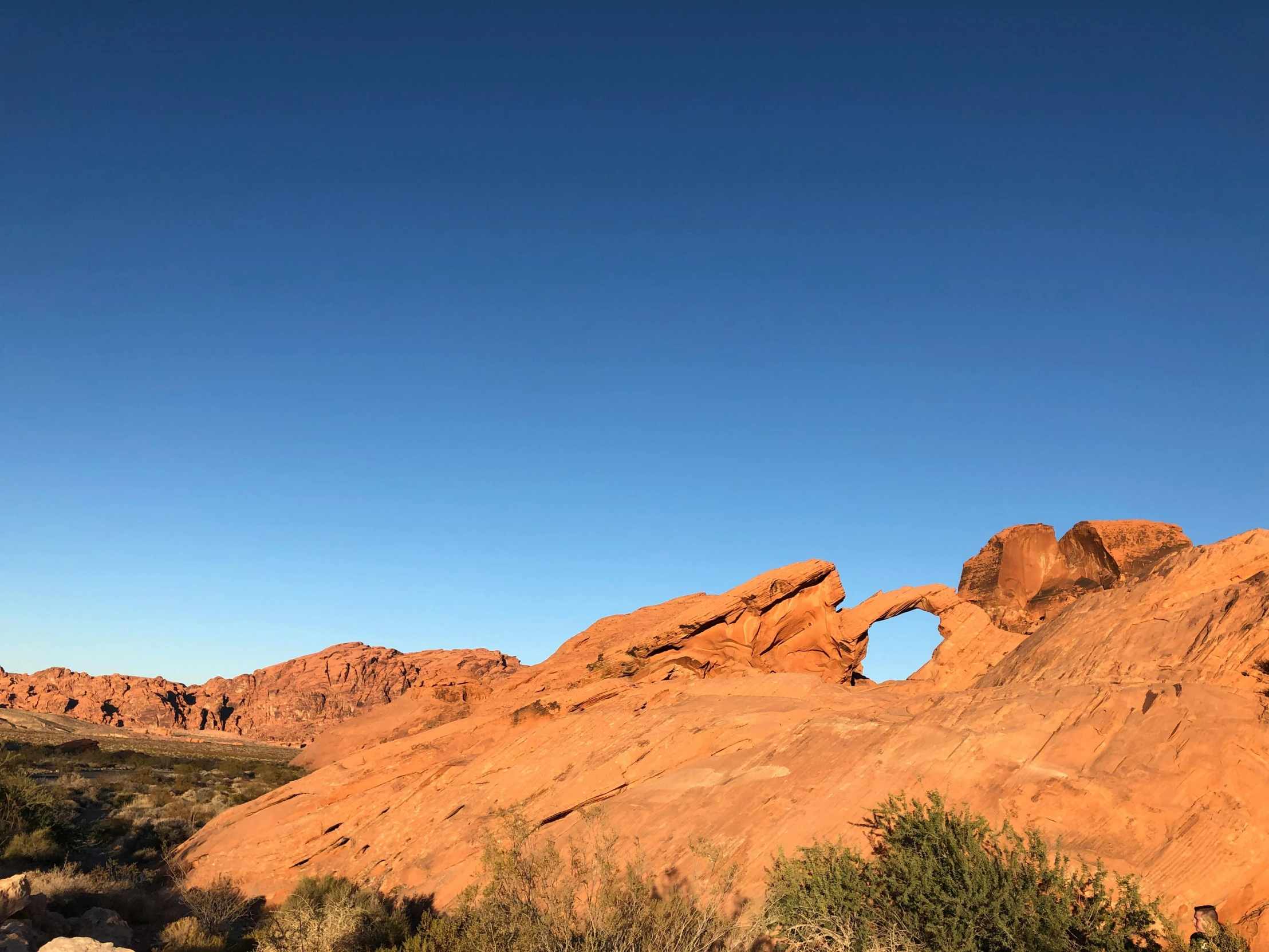 the large red rock with a arched hole