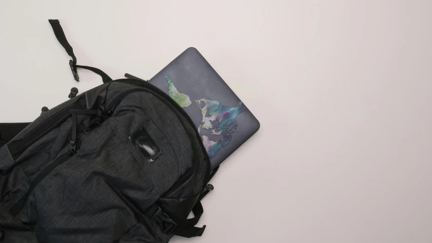 an open laptop sitting on top of a backpack