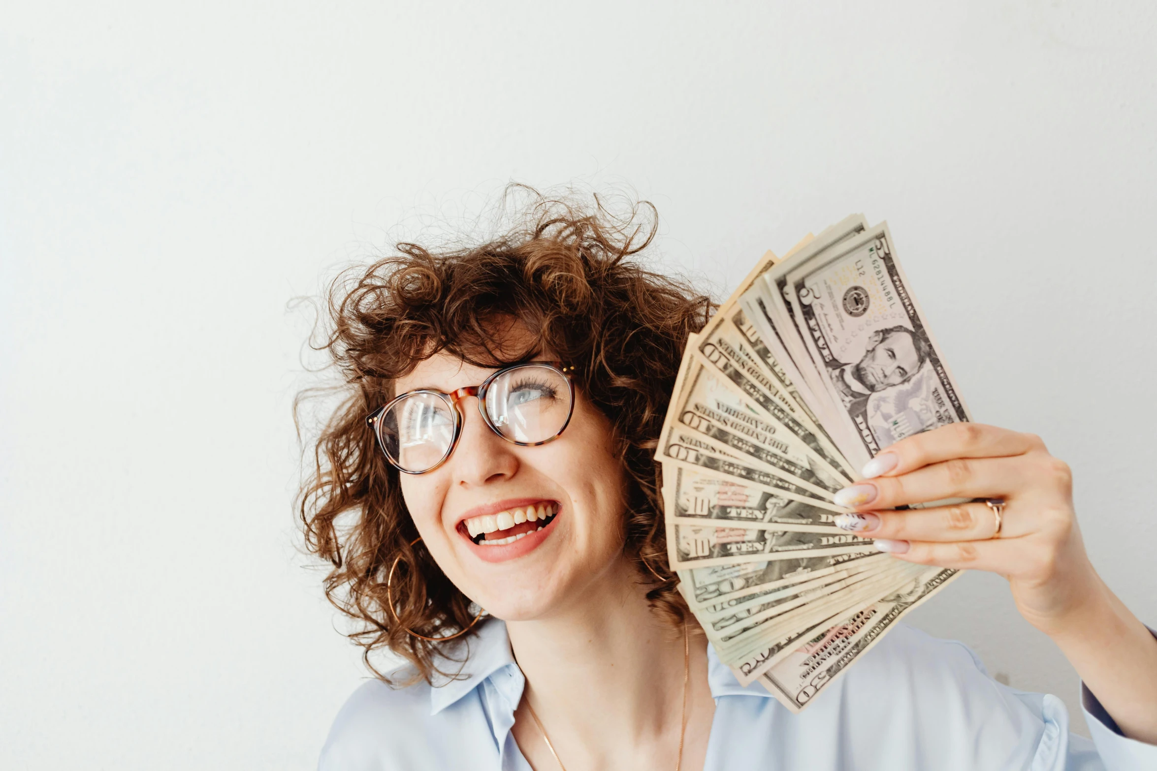 a smiling woman holding some money in her hands