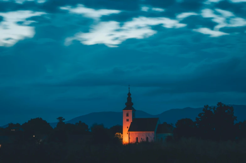 the spire of a church against a beautiful blue sky at night