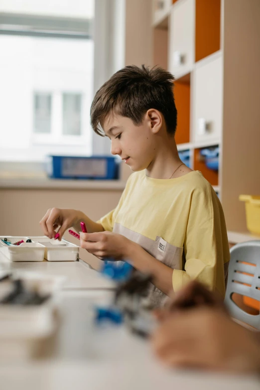 a boy in a classroom working on an project