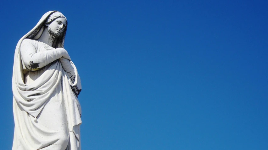 statue standing on a sunny day looking up at sky