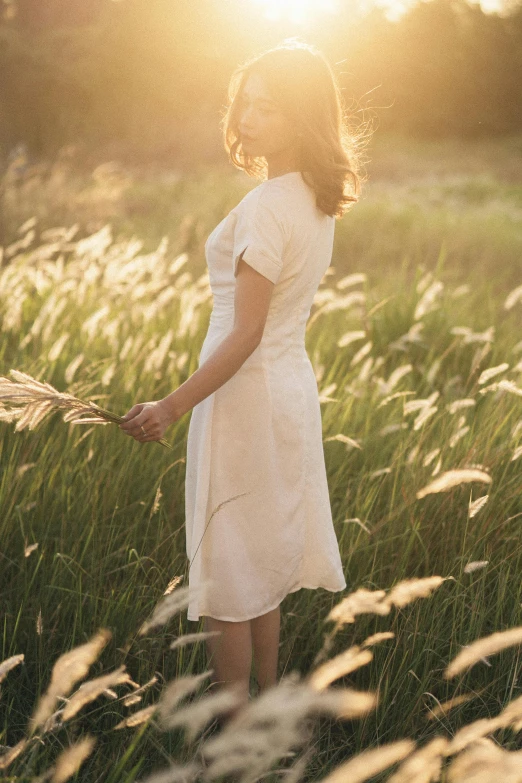 a woman standing in a field of tall grass