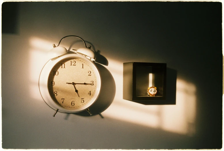 an alarm clock next to a box that is lit up