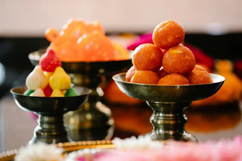 three silver bowls filled with small fruits on top of a table