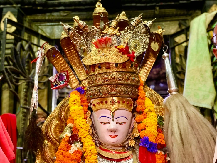 there is an indian god wearing gold and red