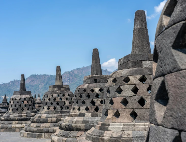 an intricate stone structure with mountains in the background