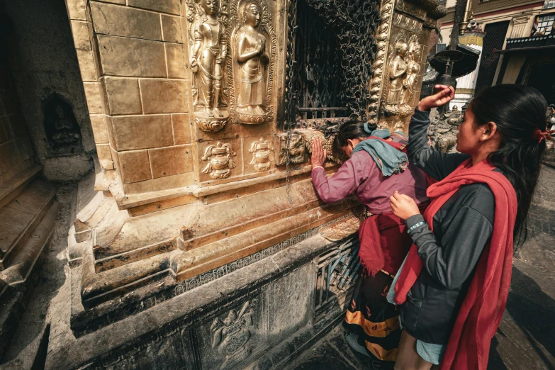 there is a woman standing next to a stone building