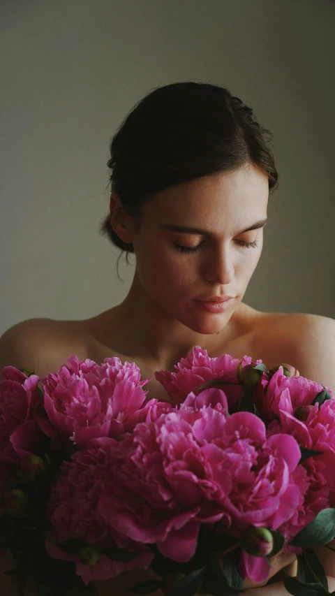 a beautiful young woman holding a large bouquet of flowers