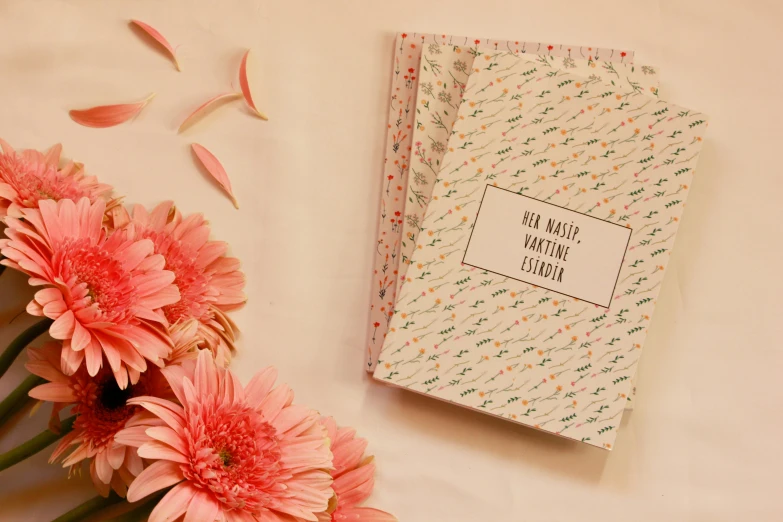 a flower, a book and some papers on a table