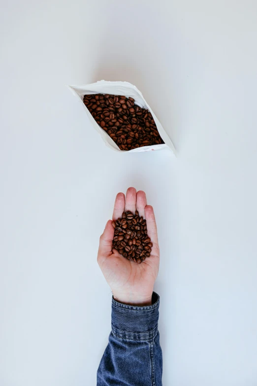 a person reaching for a bag of coffee beans