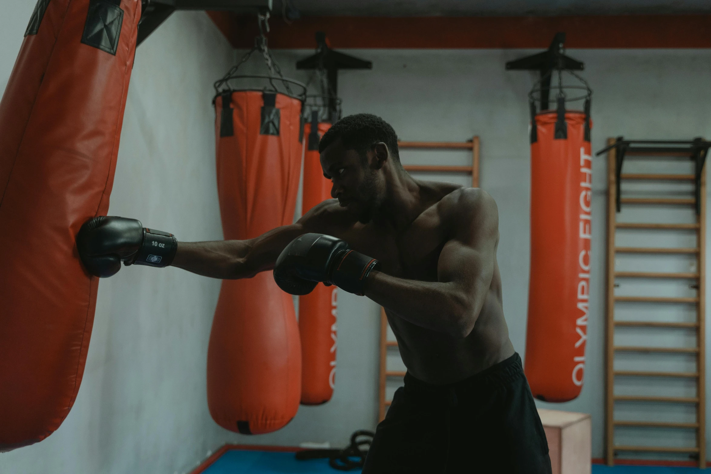 a man holding a pair of boxing gloves in a gym