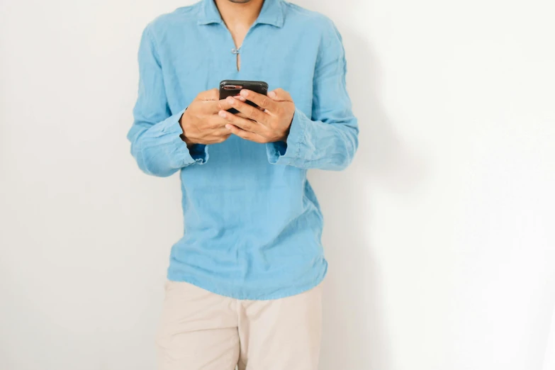 there is a young man holding his cell phone