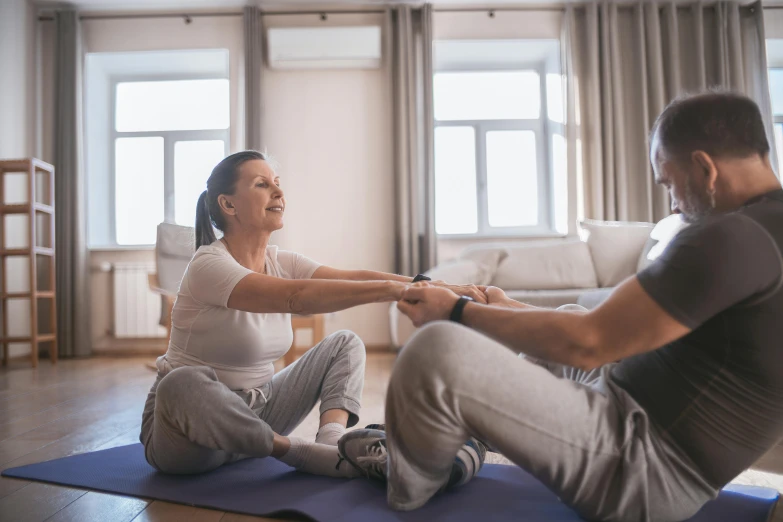 the man and woman are sitting on the yoga mat