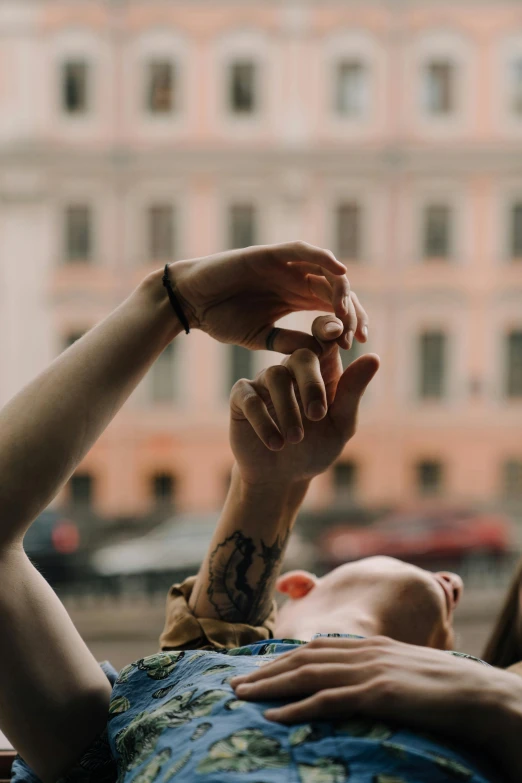 a person laying down and reaching their hand out