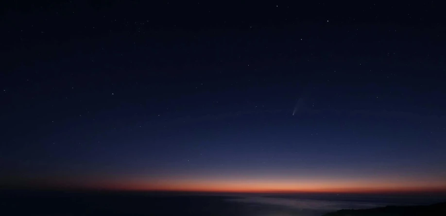 the night sky with stars above mountains at a twilight