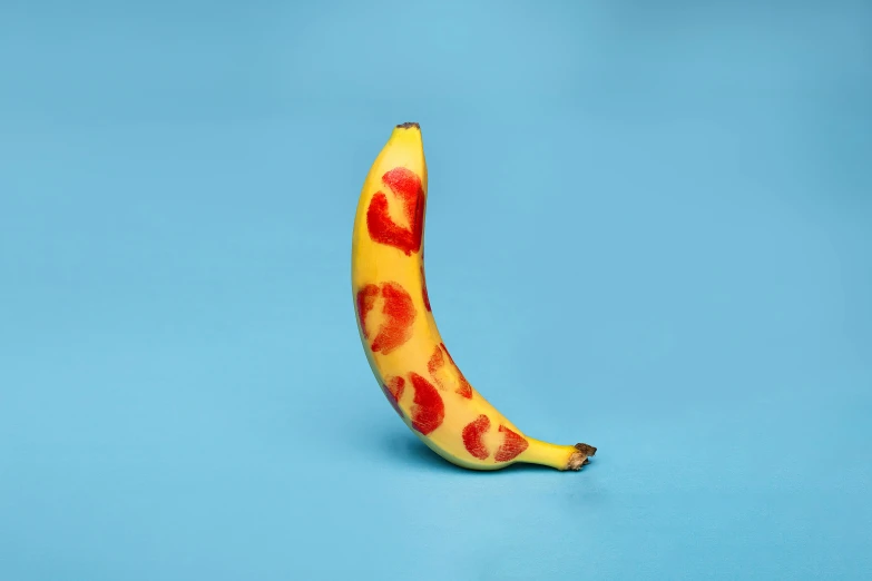 a yellow banana with red hearts on it on a blue background