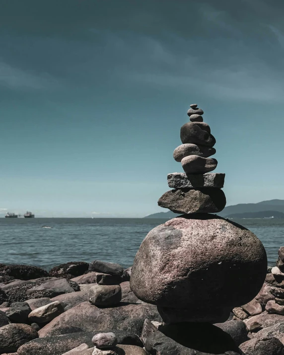 a stone stack in front of a body of water