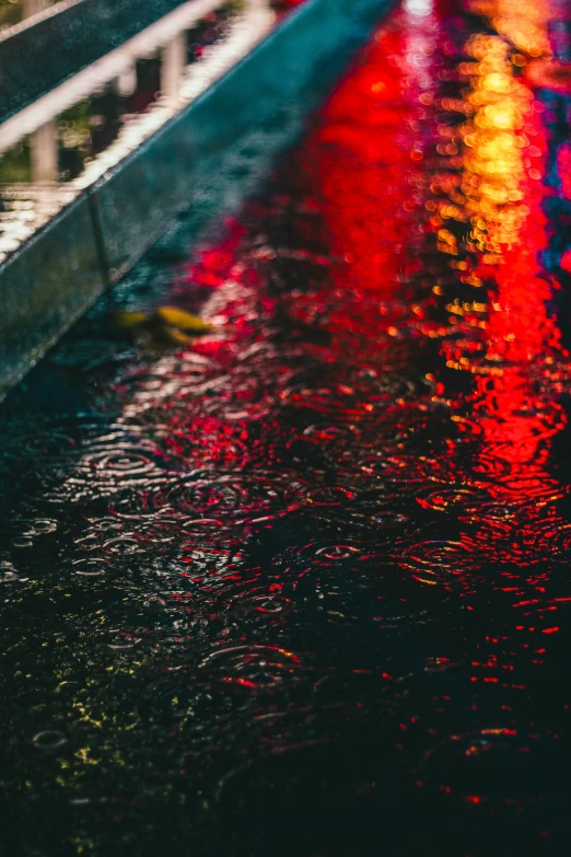 a person standing next to a road covered in rain